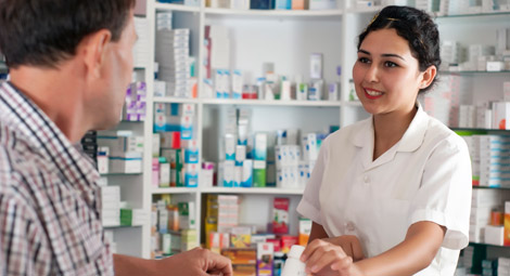 Pharmacist stood in front of medication shelves